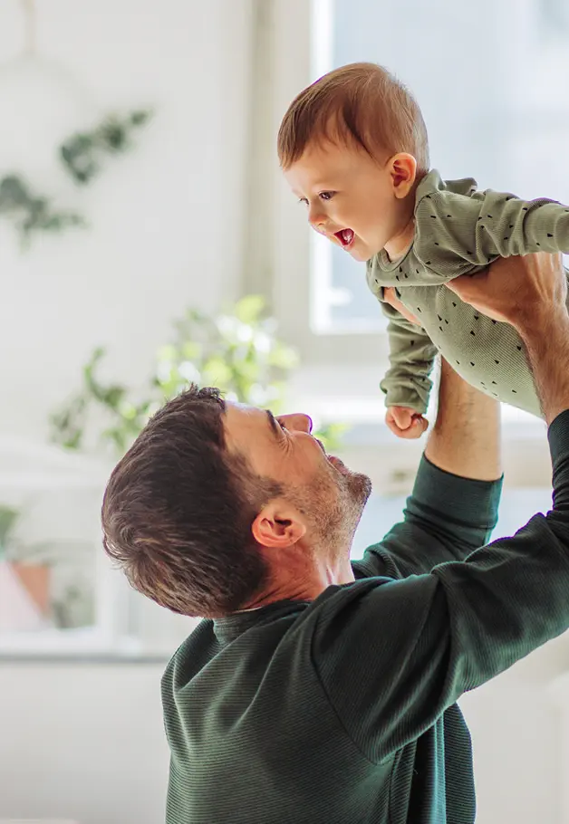 In warmer Wohnung hält Vater Kind in den Armen